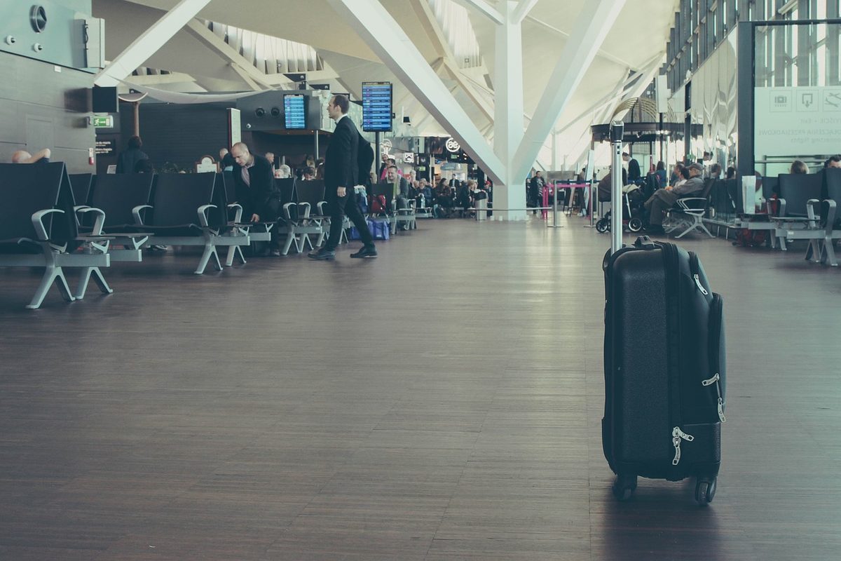 Black checked suitcase standing in an airport departure hall before a flight from the UAE